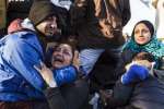 A woman refugee cries in desperation in the arms of a family member du...