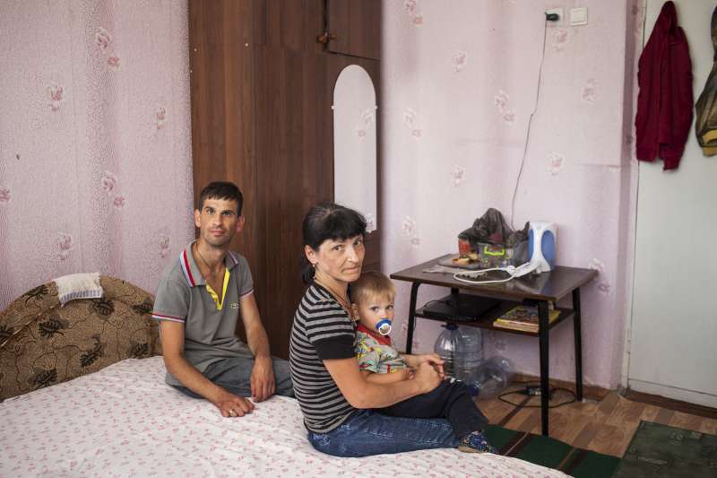 Viktoria and Aleksandr sit with 19-month-old Ivan in their room [&hellip;]