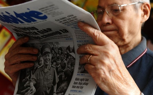 An elderly man reads a local newspaper in Hanoi, Oct. 5, 2013.
