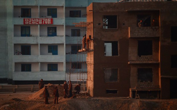 North Korean workers are seen from the window of a train as they work on a construction site along the railway heading from Pyongyang to North Pyongan province in a file photo.