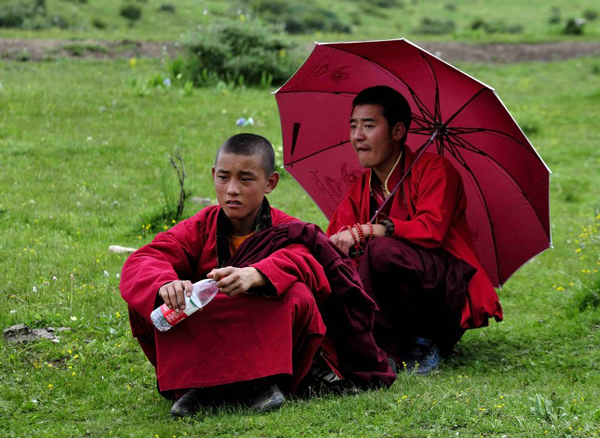 Two Tibetan monks sit on a hillside in Kardze prefecture, Sichuan province, July 7, 2013.