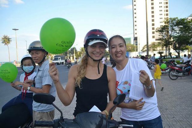 Nguyen Ngoc Nhu Quynh (R) distributes copies of the Universal Declaration of Human Rights in Nha Trang, May 21, 2013.