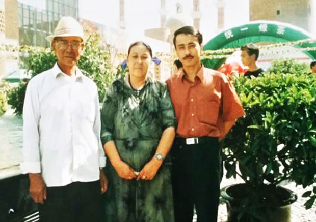 Uyghur journalist Niyaz Kahar is shown standing with his parents in an undated photo.