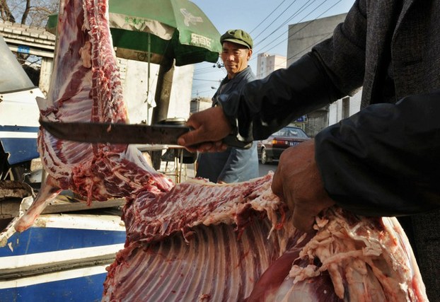 A Uyghur butcher cuts up a sheep at a market in the Xinjiang capital Urumqi, in a file photo.