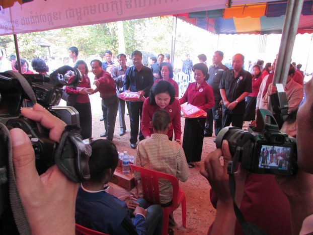 Cambodian Red Cross President Bun Rany (C) speaks with an HIV/AIDS patient in Roka village, Feb 13, 2015.