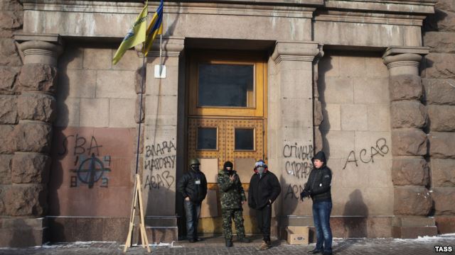 Ukrainian antigovernment protesters stand at the entrance of the Agricultural Ministry building in Kyiv which they occupied late last week.