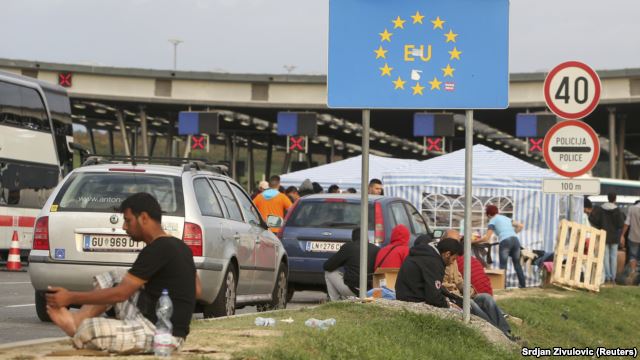 Migrants gather near a European Union sign at the Croatia-Slovenia border crossing at Bregana, Croatia, on September 19.