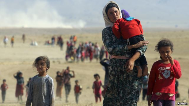Displaced people from the minority Yazidi sect, flee violence from Islamic State (IS) militants in the town of Sinjar in northern Iraq in August 2014.