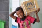 Ahmed Najee, aged 9, collects UNHCR aid items in Taizz, Yemen.