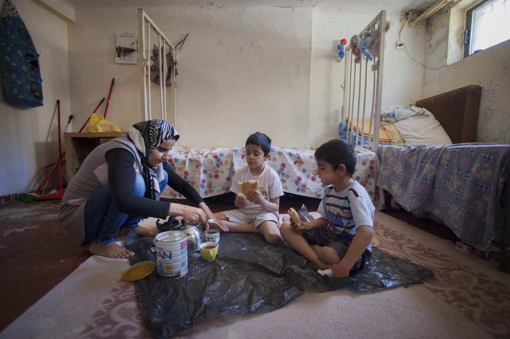 Jihan and her sons eat breakfast on the floor of their one-room home. Back in Syria, she was employed in the public sector, while her husband, Ashraf, taught at Aleppo University. The couple had high ambitions for their children’s education. Now, torn from their homeland, they sit and wait to be reunited. Photo by UNHCR/A. D’Amato/2014.