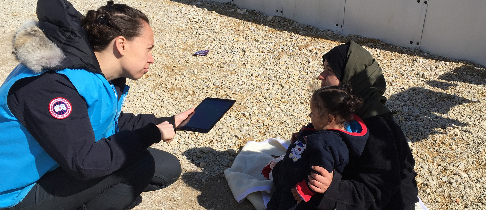 UNHCR's Emergency Lab Manager communicates with a young refugee in Macedonia.