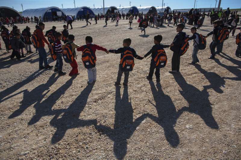 Syrian refugee children hold hands and form a ring while playing a game between classes in Adiyaman, which is one of 17 camps in Turkey.