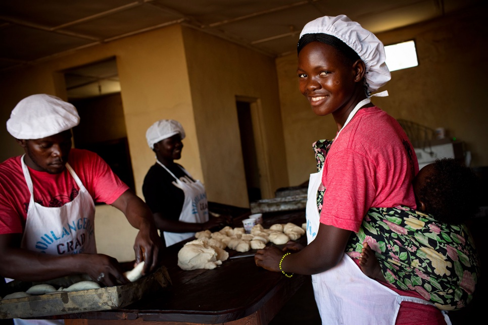 Young people affected by LRA violence -- including Marie, 20, with her child strapped to her back -- prepare croissants at Sister Angélique's bakery in Dungu, eastern Congo.