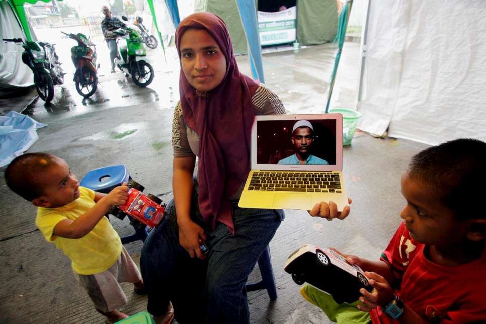 Fatima shows a photograph of her husband, Hassan, who is in Kuantan, Malaysia.