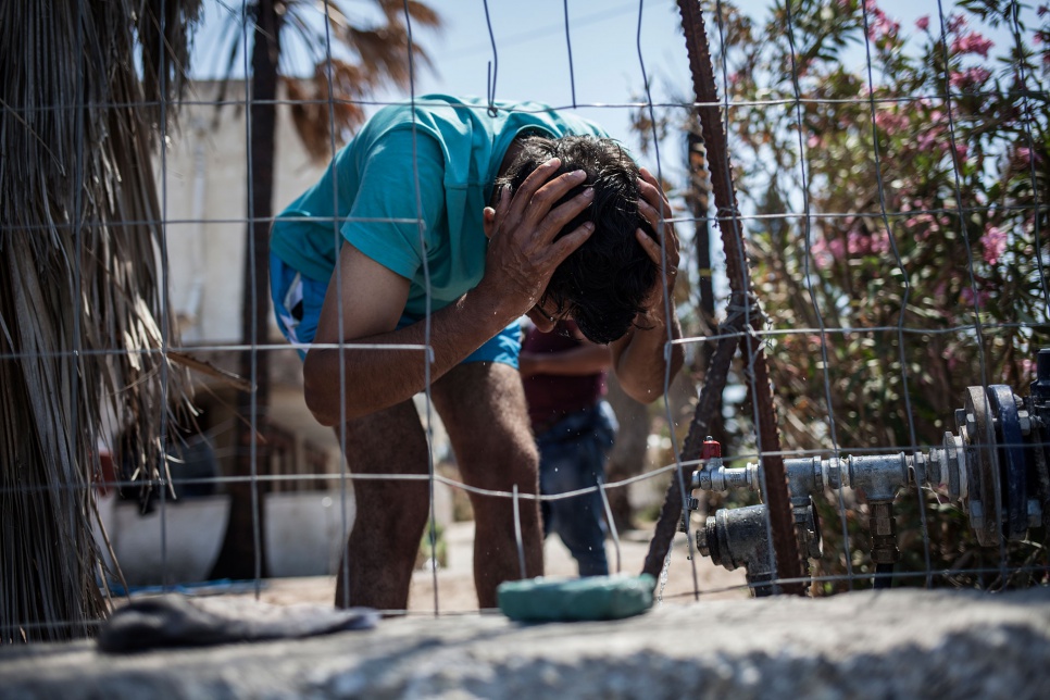 Ali washes himself outside the former Captain Elias hotel in Kos, Greece, where he has found temporary shelter.