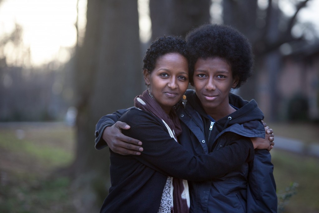 Atlanta, Georgia/Kenya Refugee/Naima Abdullahi, 36, with her son Teso, 14, outside their home in Atlanta, Georgia. Naima's uncle was murdered in Ethiopia for his involvement in the Oromo movement, her parents fled to Kenya as political refugees. Growing up in Kenya, Naima and her three siblings could not tell anyone they were refugees. It became a family secret, and they always had a fear of being caught. When Naima was 10 years old her family was resettled in San Jose, California, with the help of the IRC.Since Naima was initially the only one who spoke English, she became the family spokesperson and took on a lot of responsibilities at a young age. Eventually her family moved to Seattle and they all became U.S. citizens in 1996. Today, Naima has worked as a caseworker at the IRC in Atlanta for five years. ÒI enjoy working with my clients," she said, ÒI see my parents and I see myself in them." Naima plans to focus on women's health and well-being to empower refugee women to have a voice and educate them so they will learn to take care of themselves as their opportunities and responsibilities grow in America. "I think because of being a refugee I understand life in a completely different way. I still remember where we were, where I started, the house I lived. Today on this end I have everything at my fingertips. I have opportunities, especially as woman, that I wouldn't have had.I can make things happen for myself, whether I make it or not is all up to me." "When I lived in Nairobi we would go downtown and  UNHCR /  would give you a voucher for school uniforms and backpacks. We looked forward to that every year. UNHCR registered us and gave us refugee status. My dad worked with UNHCR as a contractor building schools. The times that he worked with UNHCR were the best times because he had a good income."/UNHCR/E.Hockstein/February 2013