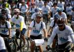 Participants ride on Sunday in a bicycle rally organized by UNHCR to m...