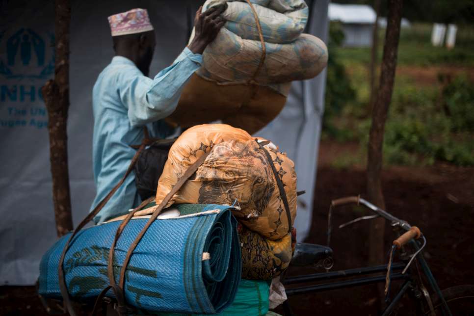 Abdul Yamuremye, 32, takes his personnal belongings into his tent. He fled violence in Burundi with his wife, Hadija Umugure, 25, and their two children.
