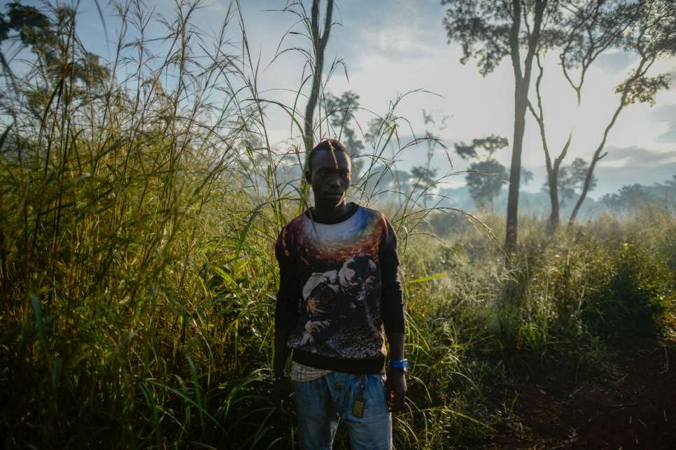 A young refugee stands in the early morning light. 