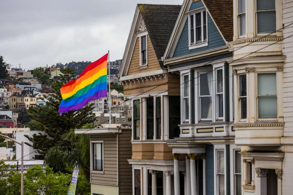 A large rainbow flag flies over the Castro District of San Francisco.
