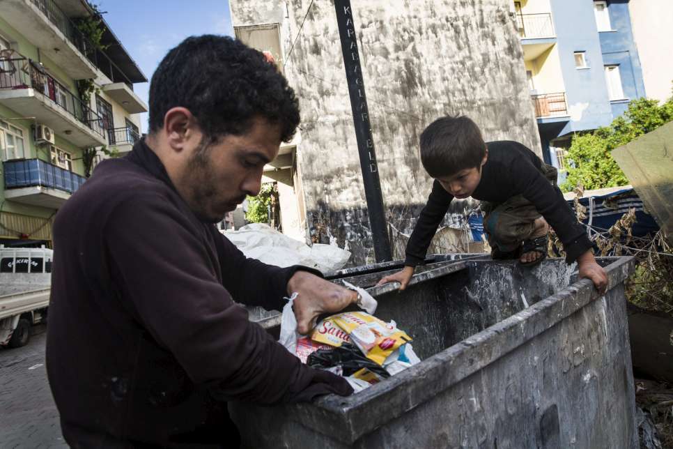 Uday climbs deep into the bins to help his father collect plastic bottles and cans.