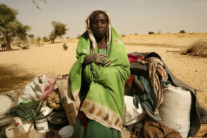 A newly arrived refugee from the Darfur region of Sudan rests next to her belongings in Seneit, Birak area, eastern Chad. 