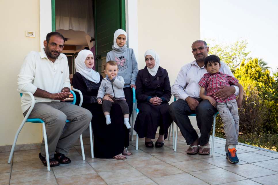 The Al Hamdan family sit outside the small bungalow they share at LM Village.