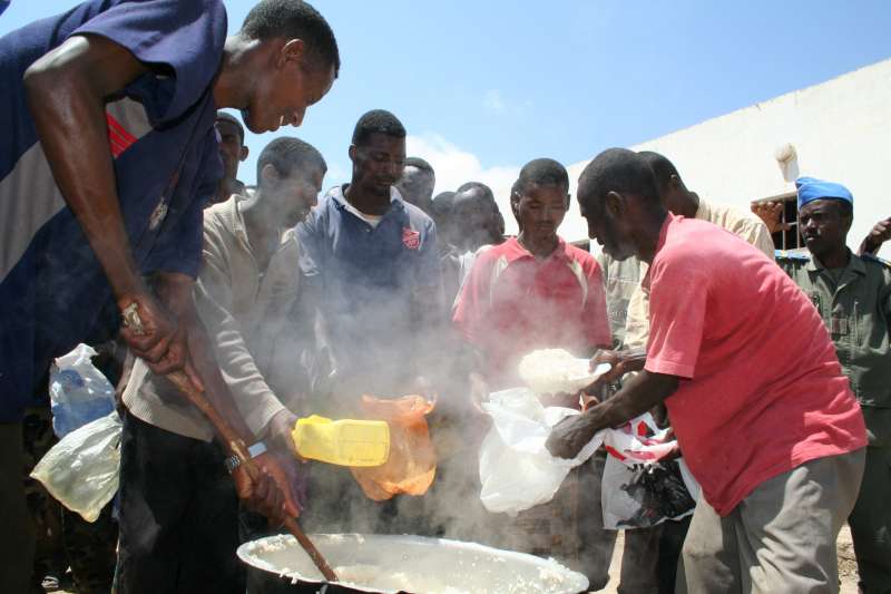 Detained Somalis and Ethiopians prepare a meal at the Obock detention centre.