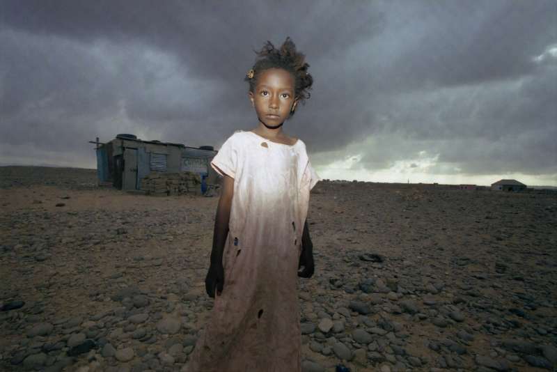A young girl crosses the barren wasteland to reach Shebele B camp on the edge of Bossaso. Once a thriving port, Bossaso is now surrounded by sprawling camps overflowing with displaced people from across the Horn of Africa.