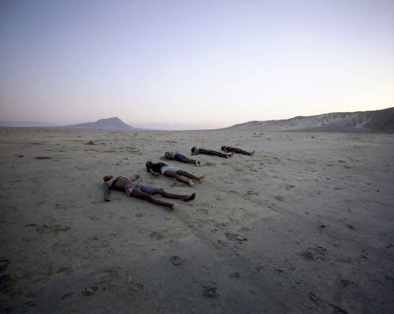 A row of corpses line Al-Bedha beach at dawn. Following the arrival of a group of 365 refugees by boat the previous night, 34 corpses were washed ashore - either beaten to death by smugglers or drowned offshore.