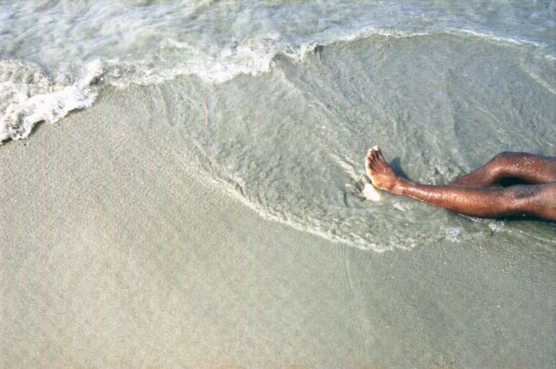 As day breaks, a man's body is washed onto the beach at Al-Bedha in Yemen by the incoming tide.