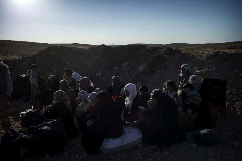 Newly arrived Syrian refugees wait  to register their names with the Jordanian military. They will then be carried by bus to Za'atri refugee camp.  