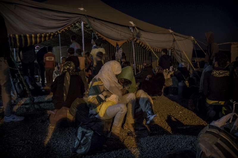 A Syrian family tends to their baby while waiting for transport to the Za'atri refugee camp. 