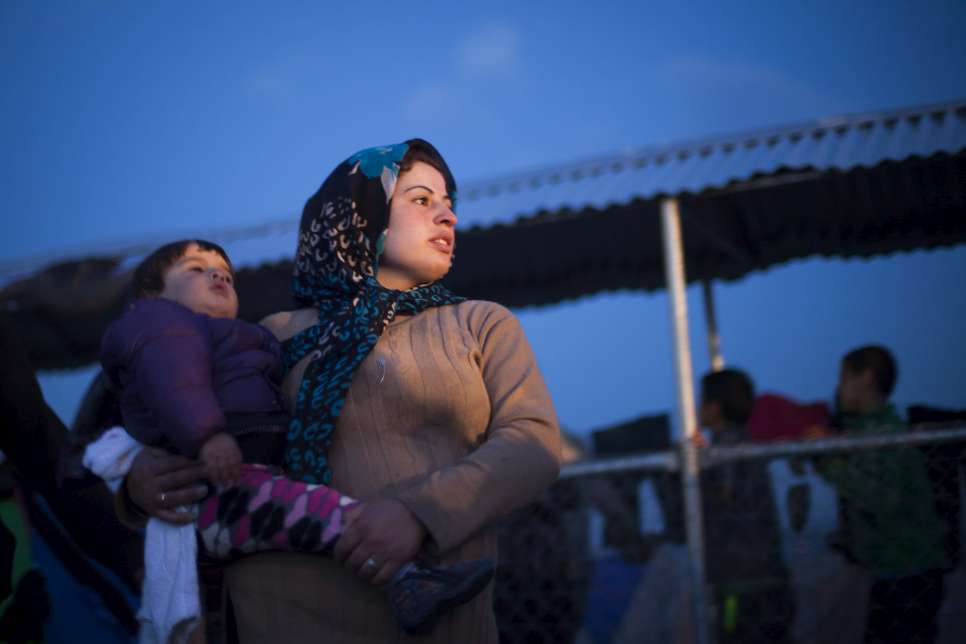 An Iraqi refugee holds her son at the makeshift camp near Idomeni.