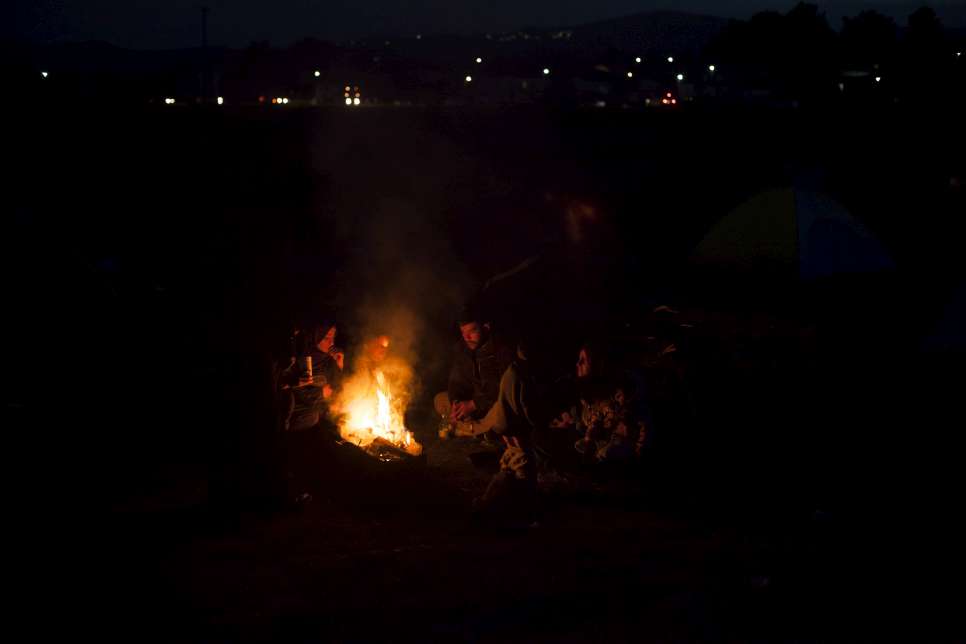 A family of refugees sits around a fire to keep warm near the village of Idomeni, on the border between Greece and the Former Yugoslav Republic of Macedonia.
