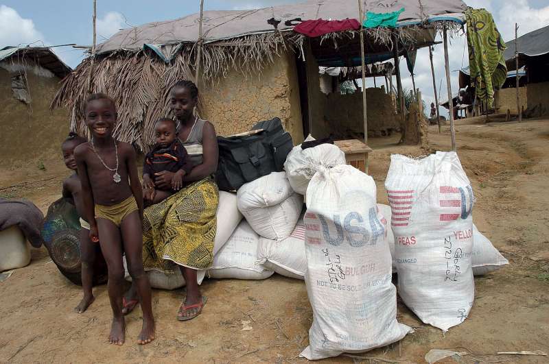 An internally displaced Liberian family waits to board the truck that will take them home after an aid distribution at Salala IDP camp, Gbarnga. 