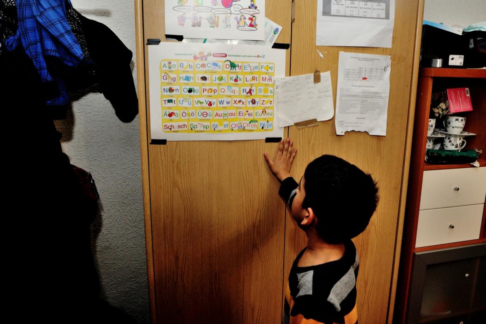 Seven-year-old Munther studies a German alphabet chart. Learning German is a priority for the entire family.