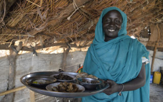 Atoma, 37 anos, deixou sua cidade natal no Nilo Azul, no Sudão, após bombas atingirem sua aldeia. Agora ela encoraja outras refugiadas a montarem suas próprias barracas e abrirem seus restaurantes no campo de refugiados de Gendrassa.  © ACNUR/ E. Byun