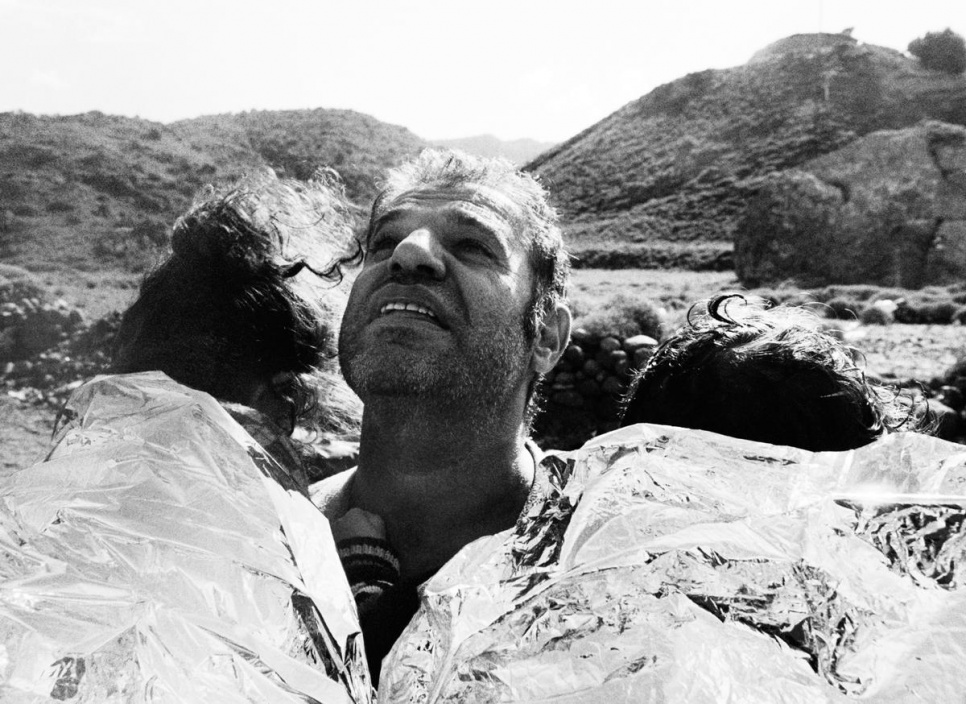 A Syrian father cries in relief after landing safely on the beach with his two children.