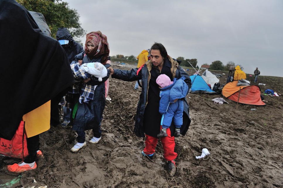 Mohamed, a refugee from Syria, waits at the Serbia -- "Croatia border with his wife Fatima and their two babies, aged three months and two years. A UNHCR protection officer there pulls them from the crowd to provide assistance.