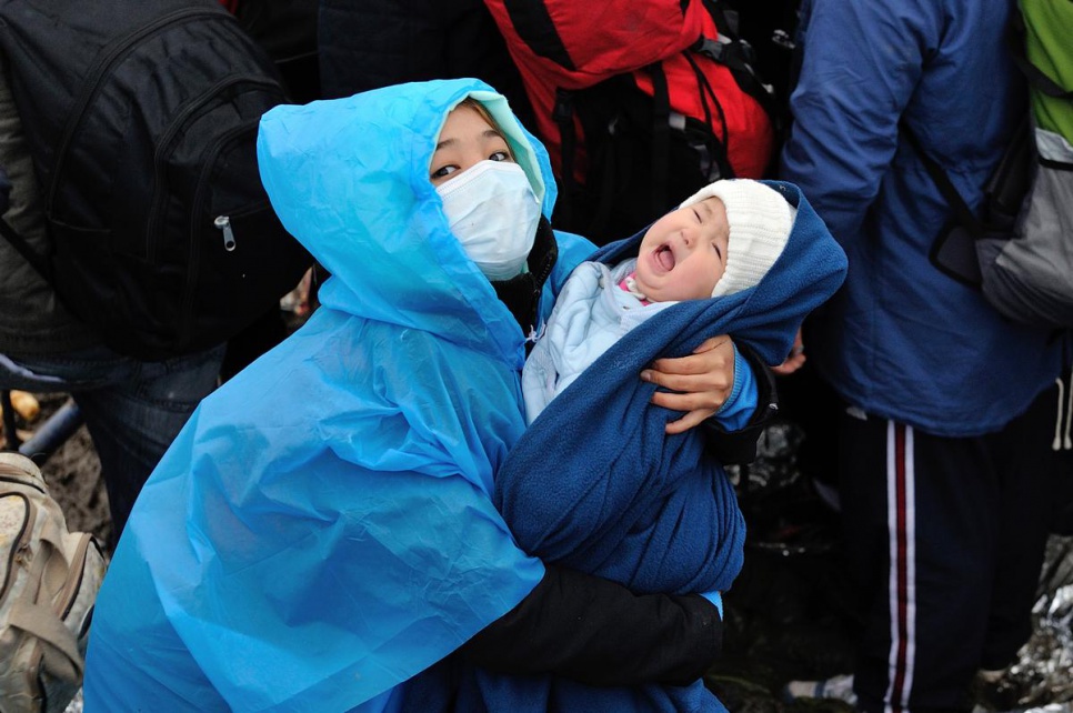 An Afghan woman wears a surgical mask for warmth while waiting at the Serbian border with Croatia.