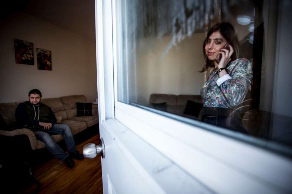 As Kevork waits for his computer to start, his sister Lara talks over the phone in the living room of their new home.