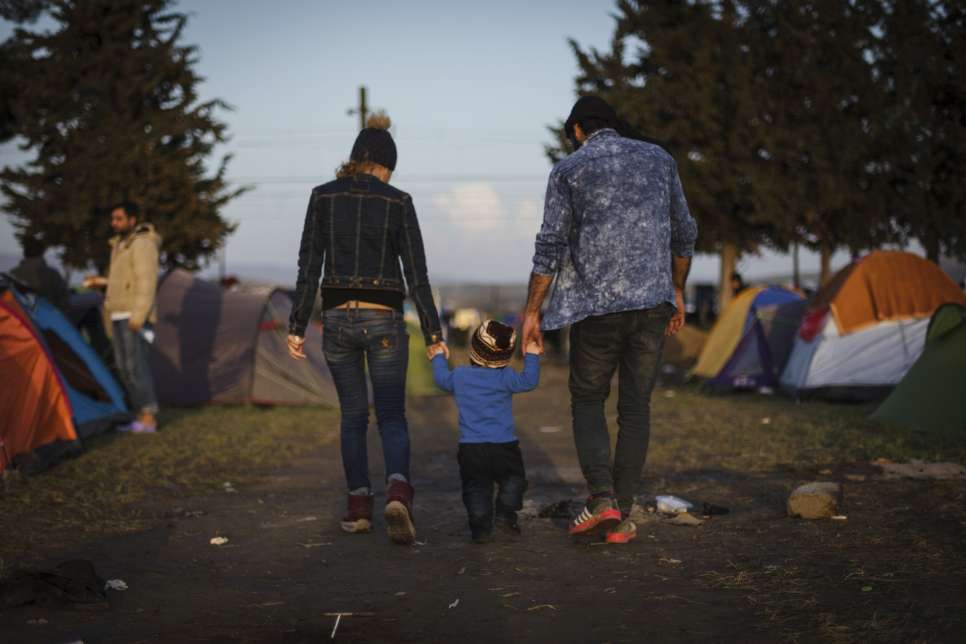 Two Syrian refugees try to maintain a sense of normalcy by taking their young boy for a stroll in the makeshift camp near Idomeni, Greece.
