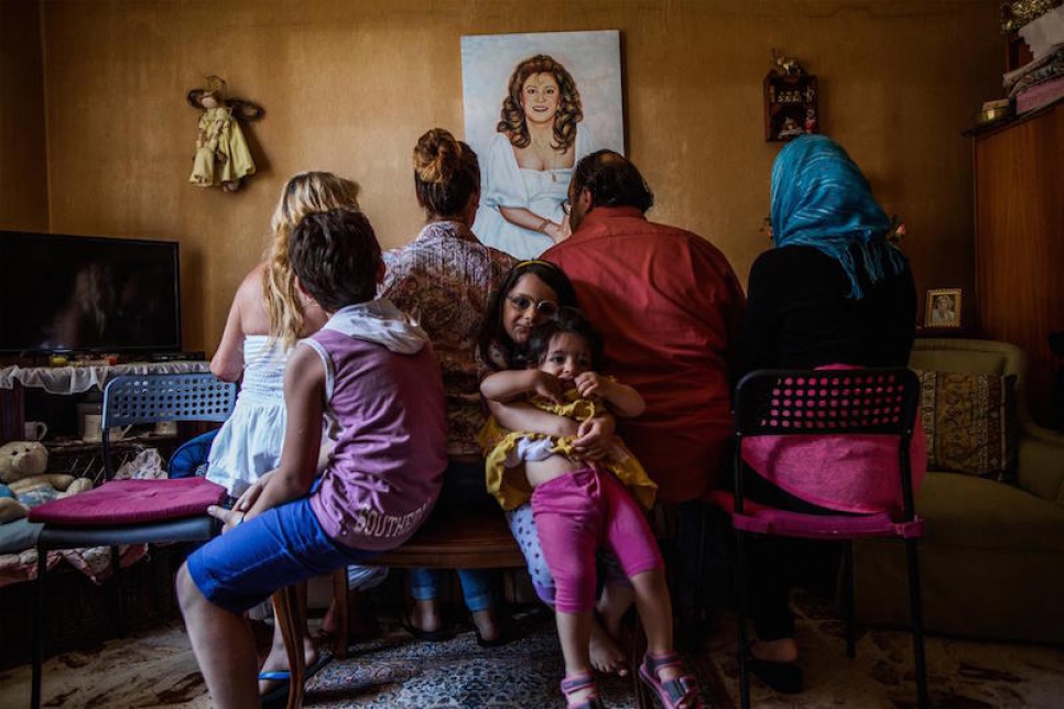 Alberto and his family pose for a portrait. All of the adults have decided to show only their backs because they fear retaliation against their families still in Syria.