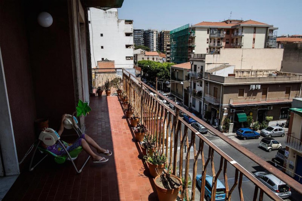 Alberto's children play on the balcony at the family's rented apartment on the outskirts of Catania.