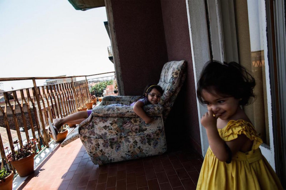 Alberto's daughters relax on the balcony of their apartment in Catania.