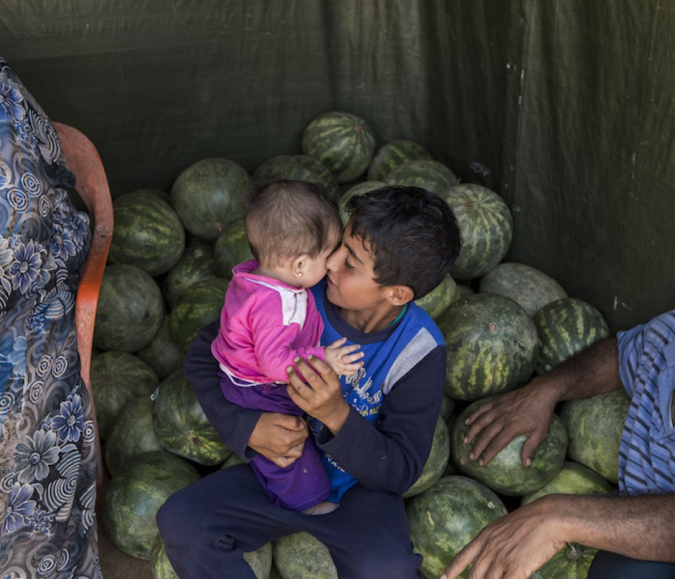 Saleh holds his young niece outside his family shelter at the Mar el Kokh tented settlement.