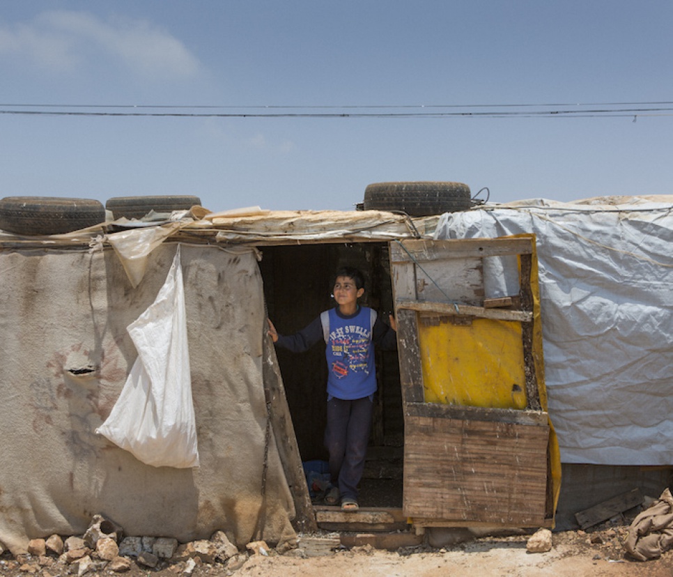 Syrian refugee Saleh stands in the doorway of his pigeon coup at the Mar el Kokh tented settlement.