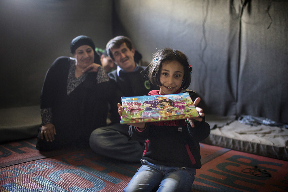 Jordan. Nine-year-old Syrian refugee, Solaf, with her father Ahmad, 49, her mother Ruwaidah, 44 and brother Munaf, 21, at Azraq refugee camp