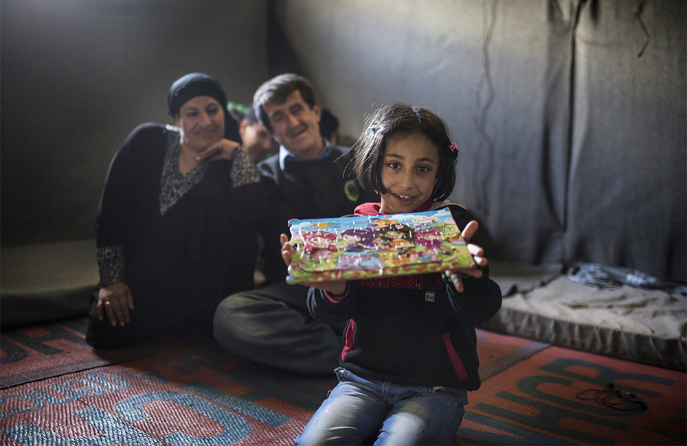 Jordan. Nine-year-old Syrian refugee, Solaf, with her father Ahmad, 49, her mother Ruwaidah, 44 and brother Munaf, 21, at Azraq refugee camp